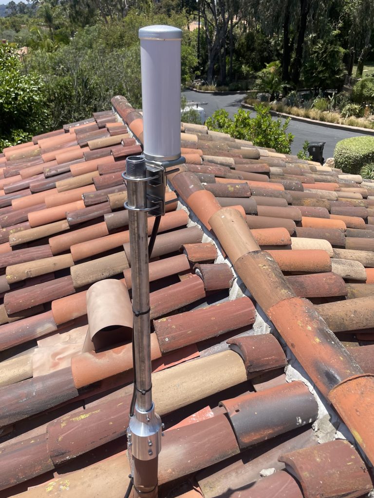 Cellular signal booster antenna mounted on a roof